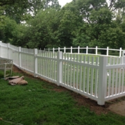 A decorative metal fence with intricate designs, installed along a pathway in a residential outdoor setting