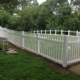 A decorative metal fence with intricate designs, installed along a pathway in a residential outdoor setting