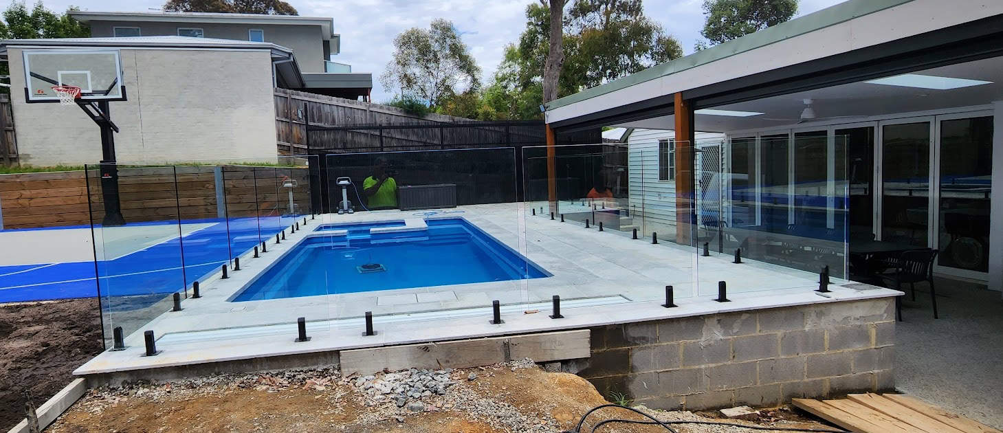 Glass pool fence surrounding a swimming pool, ensuring child safety.