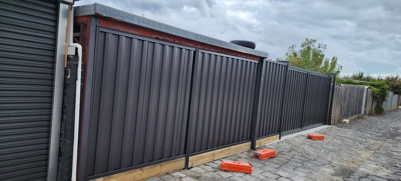 colorbond fence with gate installed around a residential backyard